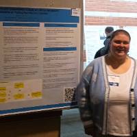 Kaitlyn Martin talking to a student about her poster presentation